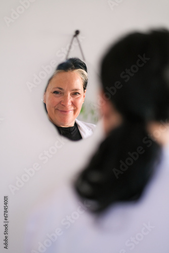 Reflexion of health practioner looking in the mirror  photo