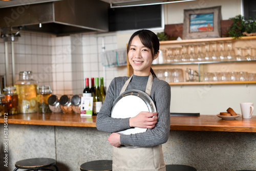 レストランで働き、笑顔でカメラを見ている若いアジア人の女性店員 photo