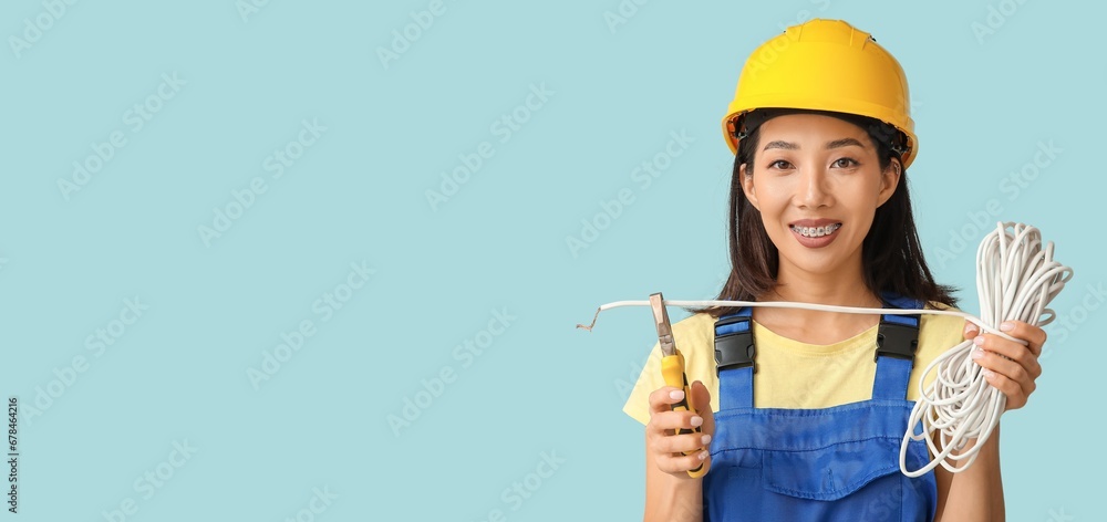 Asian female electrician on light blue background with space for text Asian female electrician on light blue background with space for text
