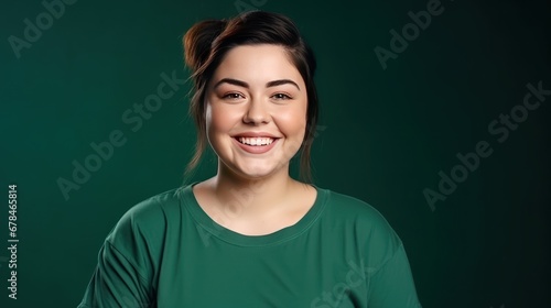 Portrait of a funny young chubby dressed casual t-shirt smiling on a dark green background