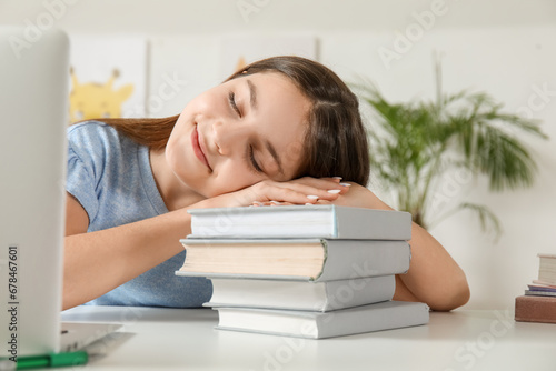 Little girl with stack of schoolbooks at home