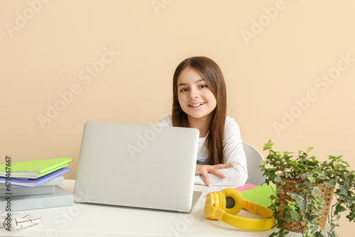 Little girl with laptop doi...