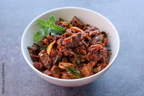 Kerala style beef or Mutton dry fry. delicious spicy Beef fry in clay pot . beef curry for ghee rice, kappa, appam, parotta, puttu, bread and chappathi, beef roast. Indian cuisine .