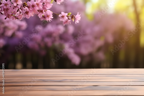 An empty wooden table with a blurred background with pink flowers. Wooden table for product presentation with a Garden in the background. Copy space for text.