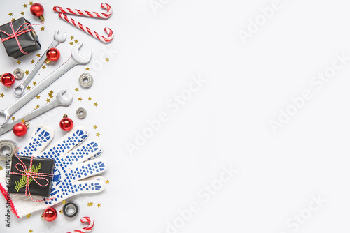 Composition with tools for car repair, Christmas gifts and decorations on light background