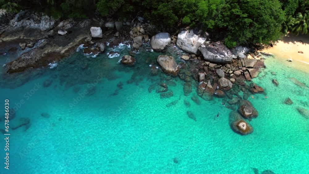 Drone video of 4 people snorkelling near huge granite stones, white sandy beach, turquoise transparent Indian ocean water, Mahe, Seychelles 30fps Drone video of 4 people snorkelling near huge granite stones, white sandy beach, turquoise transparent Indian ocean water, Mahe, Seychelles 30fps