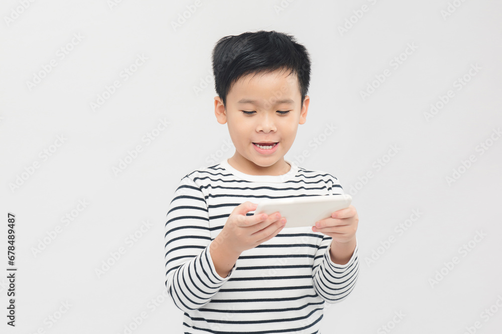 Serious little boy using smartphone over white banner background. Serious little boy using smartphone over white banner background.
