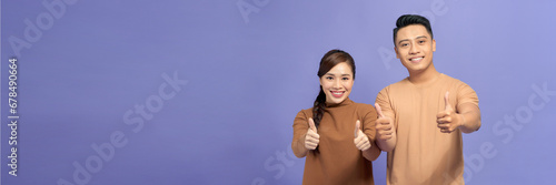 Happy Asian couple love excited smiling with thumb up gesture isolated on violet