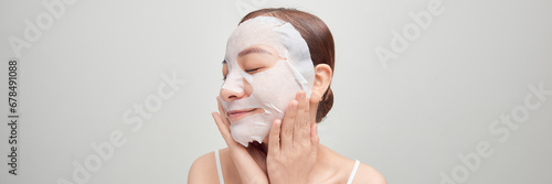 Girl taking care of skin complexion with sheet mask on her face.
