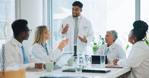 Man, doctor and team in meeting for healthcare, planning or strategy together at hospital or office. Group of medical employees in teamwork, discussion or collaboration for presentation at clinic photo