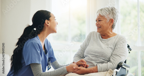 Happy woman, nurse and holding hands with senior in wheelchair, support or trust for healthcare advice at home. Medical doctor, caregiver or person with a disability smile for care or help at house photo