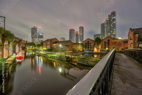 Photography Castlefield in Manchester, UK, at night with the modern skyline in the back