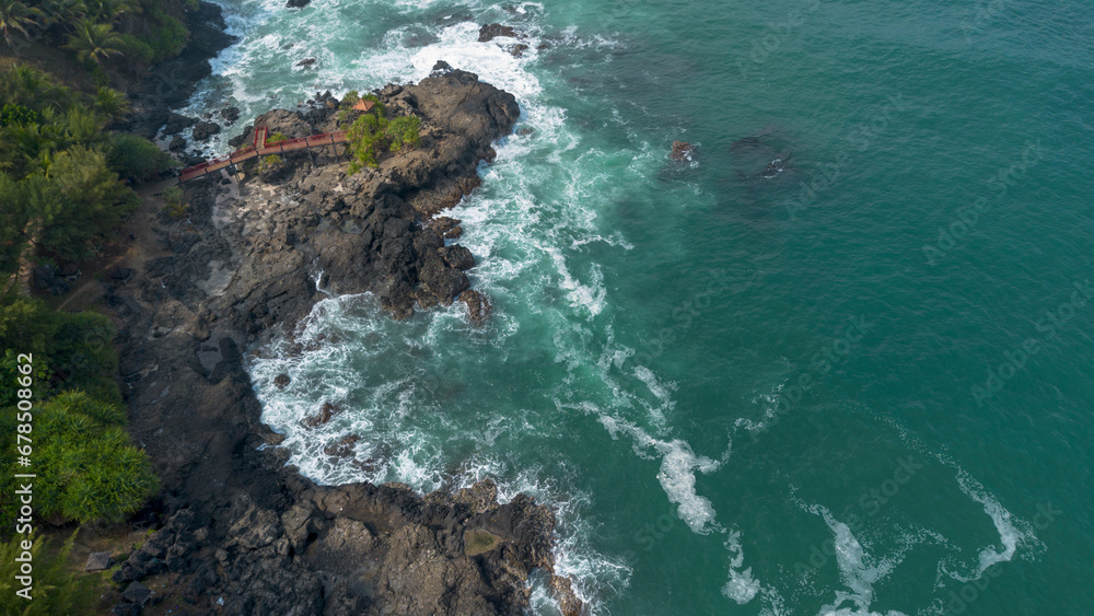 The beauty of Menganti beach, Kebumen, Central Java, Indonesia, a beach with calm sea waves and coral cliffs and green trees