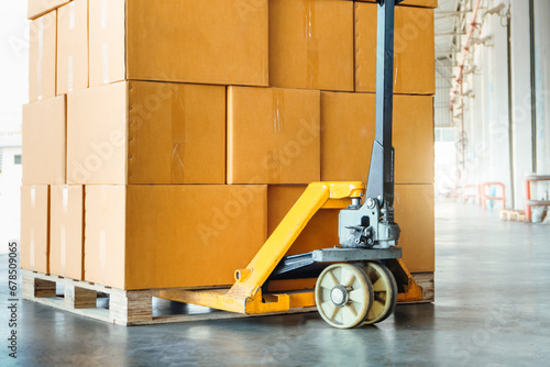 Package Boxes Stack on Pallet and Hand Pallet Truck. Cartons, Cardboard Boxes. Storehouse, Distribution, Supply Chain. Supplies Warehouse Shipping.	
