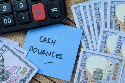 Concept of Cash Advances write on sticky notes isolated on Wooden Table.