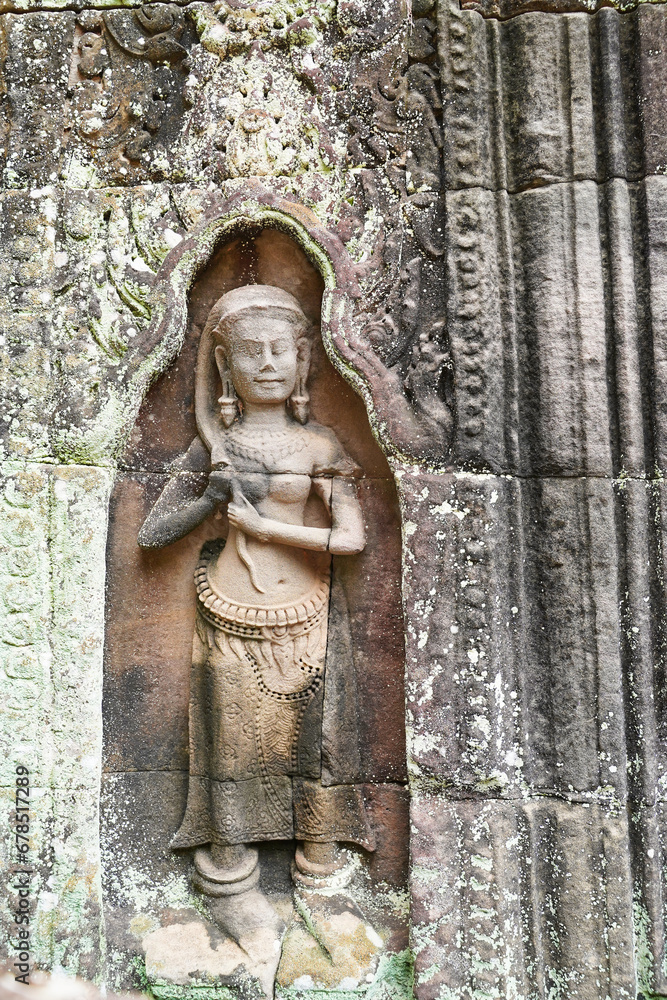 Apsara - Stone bas relief depicting a Heavenly nymph and celestial dancer at the courts of the Gods adjusting her long hair, carved in stone at Preah Khan temple at Siem Reap, Cambodia, Asia