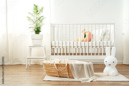 Interior of nursery room with baby crib and cradle photo