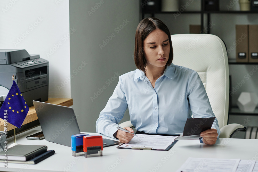 Professional specialist making documents for visa during her work in office Professional specialist making documents for visa during her work in office