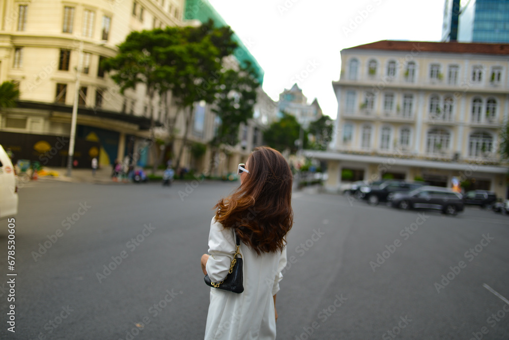 Young woman wearing sunglasses in city, colorful buildings and feel the warm. Exploring this bustling metropolis is a true adventure