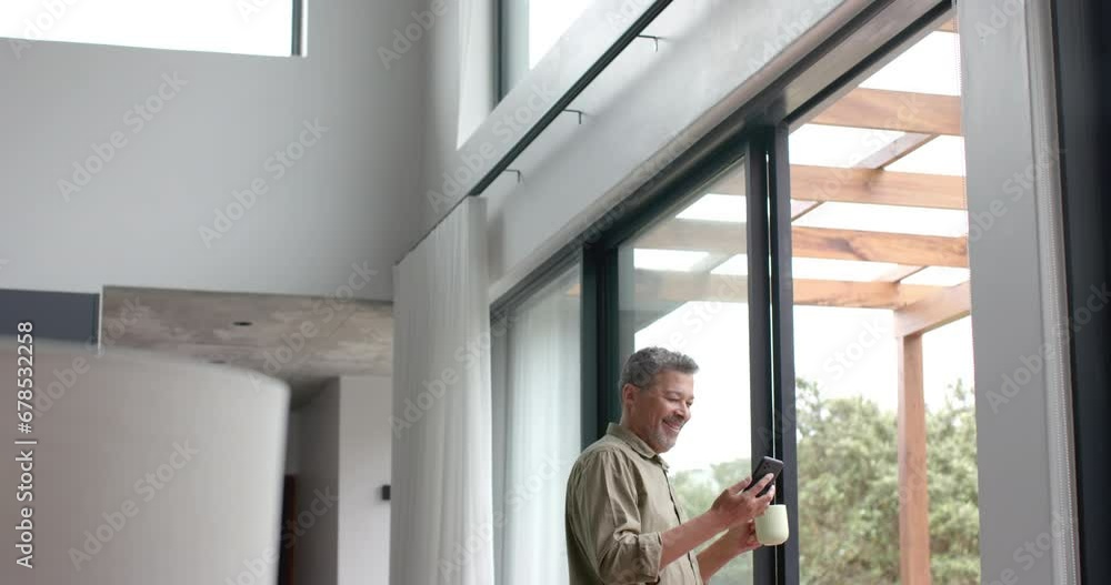custom made wallpaper toronto digitalHappy senior biracial man using smartphone by window in living room, copy space, slow motion