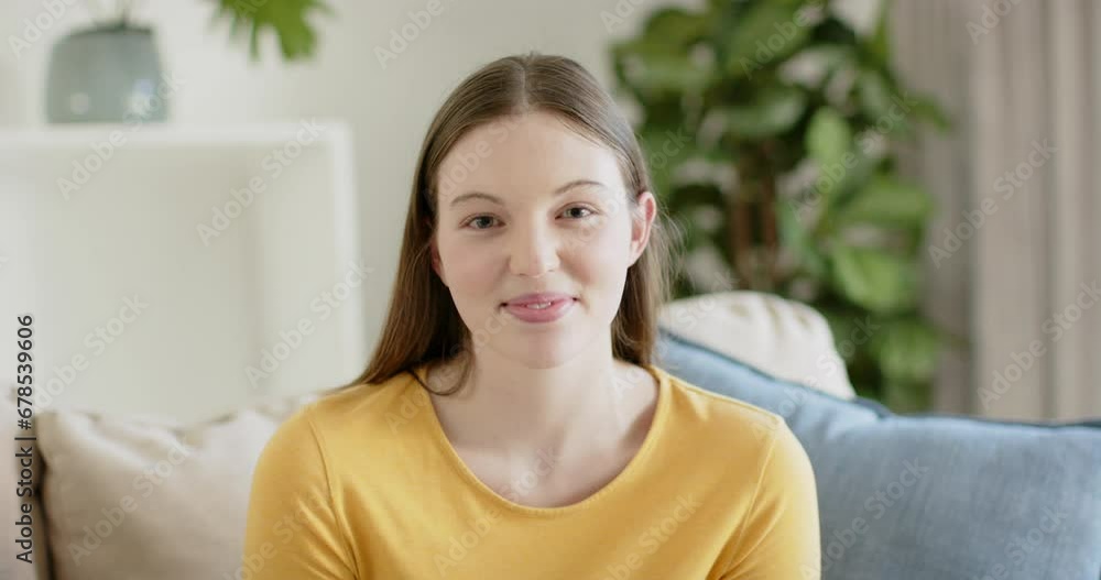 Portrait of happy caucasian woman sitting on sofa and smiling at home, in slow motion Portrait of happy caucasian woman sitting on sofa and smiling at home, in slow motion