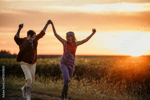 Man and woman adult relationship in outdoor love leisure activity enjoying golden sunset holding hands with love and tenderness