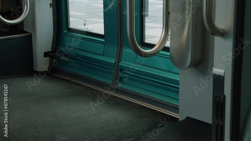 Shiny teal doors close on modern urban public transit commuter train photo
