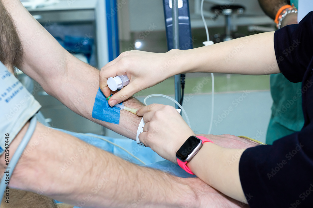 Inserting a catheter into a vein in a patient's arm in the hospital