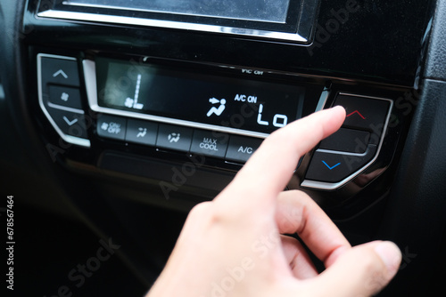 A car driver hand adjusting the air conditioner temperatur photo