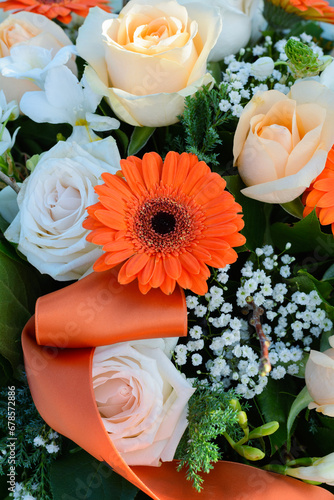 One orange gerbera in the bouquet. Several beautiful orange and white flowers in the sunlight. Orange gerbera and a bunch of other flowers in the sun
