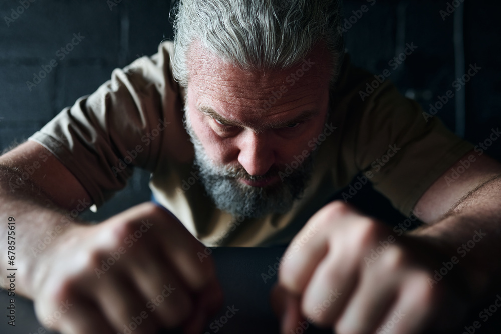 Mature man in rage clenching his fists during his depression Mature man in rage clenching his fists during his depression