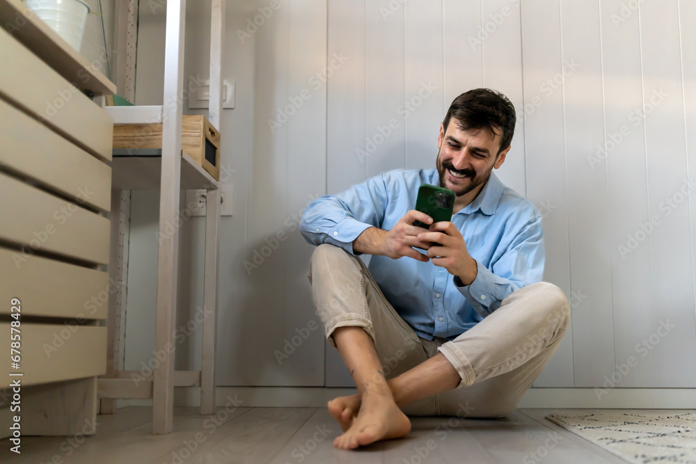 Young man happy to exchange messages with friends uses free internet connection on electronic gadget