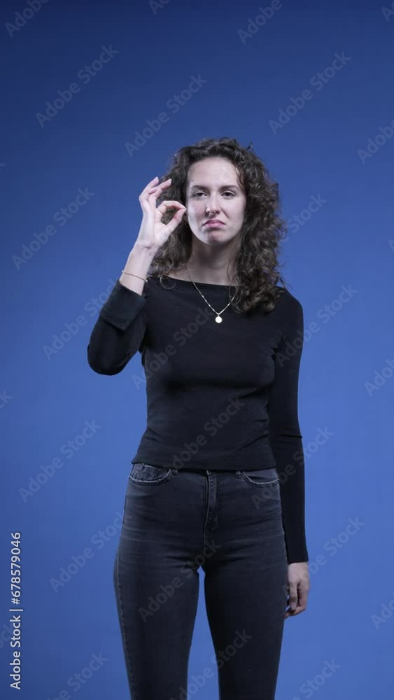 Woman showing signs of approval by giving THUMBS UP and giving OK sign with hand, applauds to camera engaging and supporting cause looking directly at camera, vertical video Woman showing signs of approval by giving THUMBS UP and giving OK sign with hand, applauds to camera engaging and supporting cause looking directly at camera, vertical video