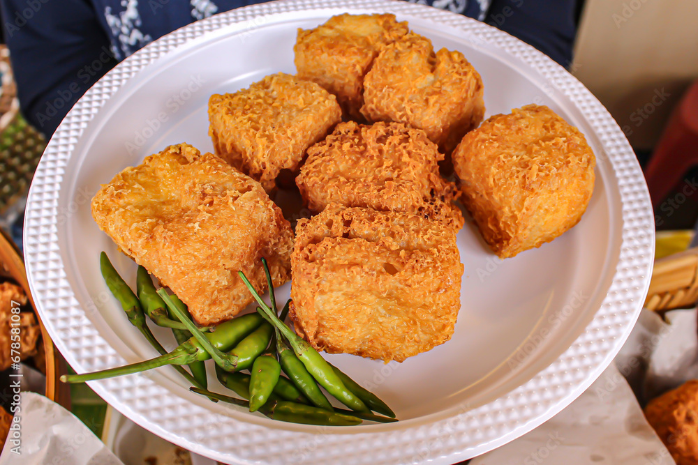 Close up of Kalasan tofu on a white plastic plate ready to eat Close up of Kalasan tofu on a white plastic plate ready to eat
