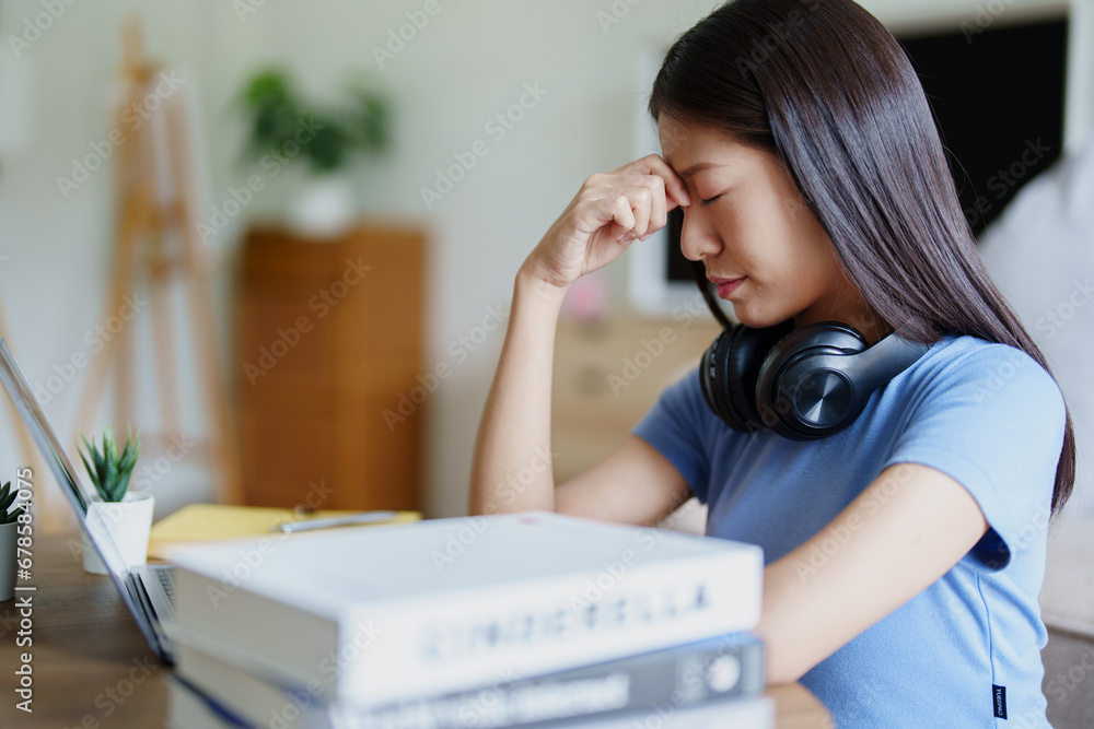 Studying online, beautiful Asian female student show symptoms burnout syndrome student studying online at home Studying online, beautiful Asian female student show symptoms burnout syndrome student studying online at home