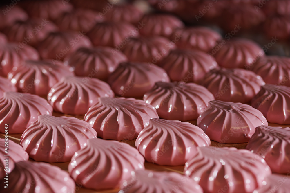 Closeup rose marshmallows or pink zephyr in confectionery on conveyor line of food factory Closeup rose marshmallows or pink zephyr in confectionery on conveyor line of food factory