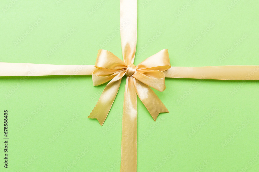 Top view of gold ribbon rolled and yellow bow isolated on colored background. Flat lay with copy space Top view of gold ribbon rolled and yellow bow isolated on colored background. Flat lay with copy space