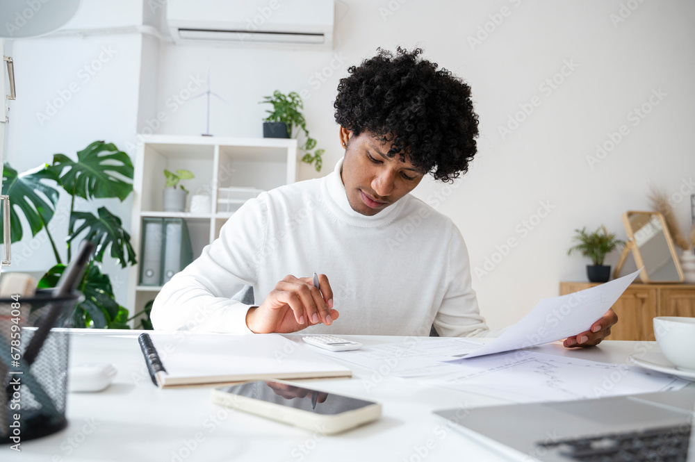 Businessman using calculator on desk at home office Businessman using calculator on desk at home office
