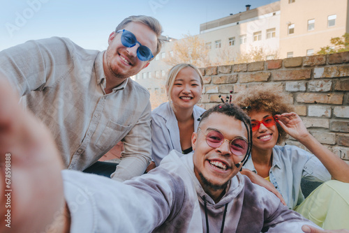 Smiling man taking selfie with friends on rooftop photo