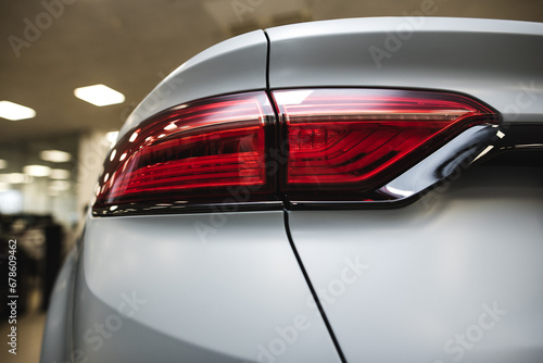 Closeup of car tail light on a grey car.