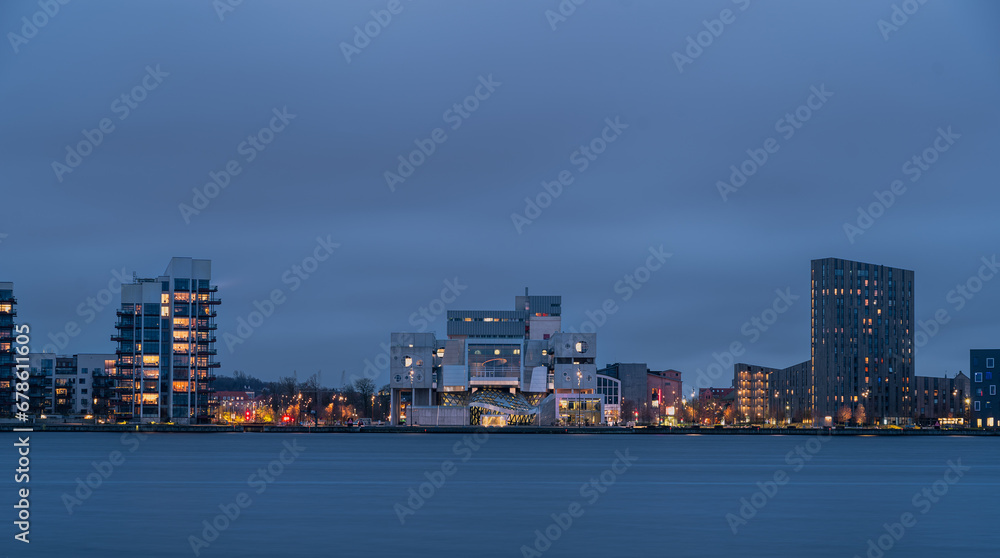 Evening cityscape panorama of the illuminated Aalborg, North Jutland Region (Nordjylland), Denmark. Famous landmark - House of Music (Musikkens Hus) is in the center