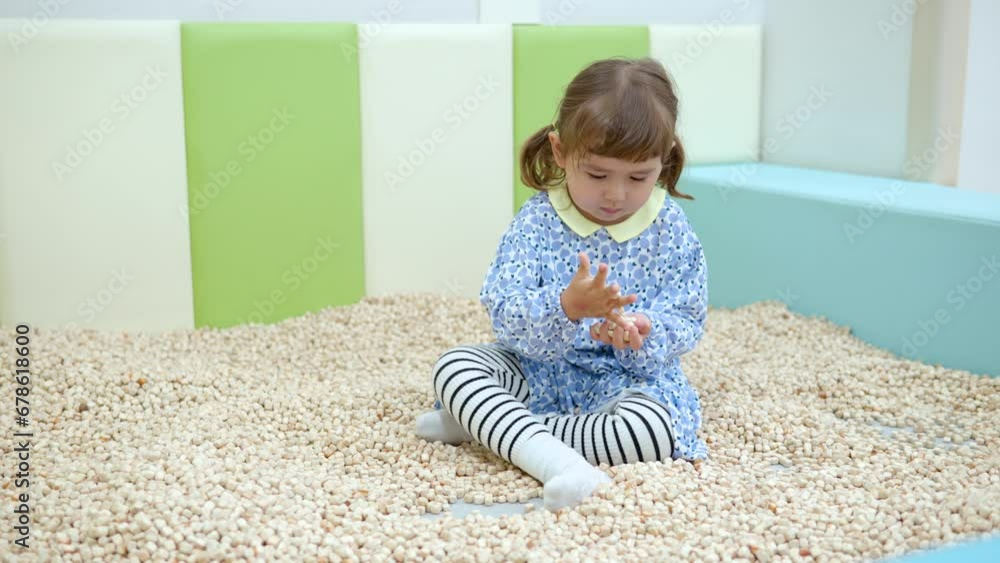 Kids Cafe - 3-year-old Mixed-race Little Girl Playing Wooden Blocks Sand Pool At Indoor Playroom. Kids Cafe - 3-year-old Mixed-race Little Girl Playing Wooden Blocks Sand Pool At Indoor Playroom.