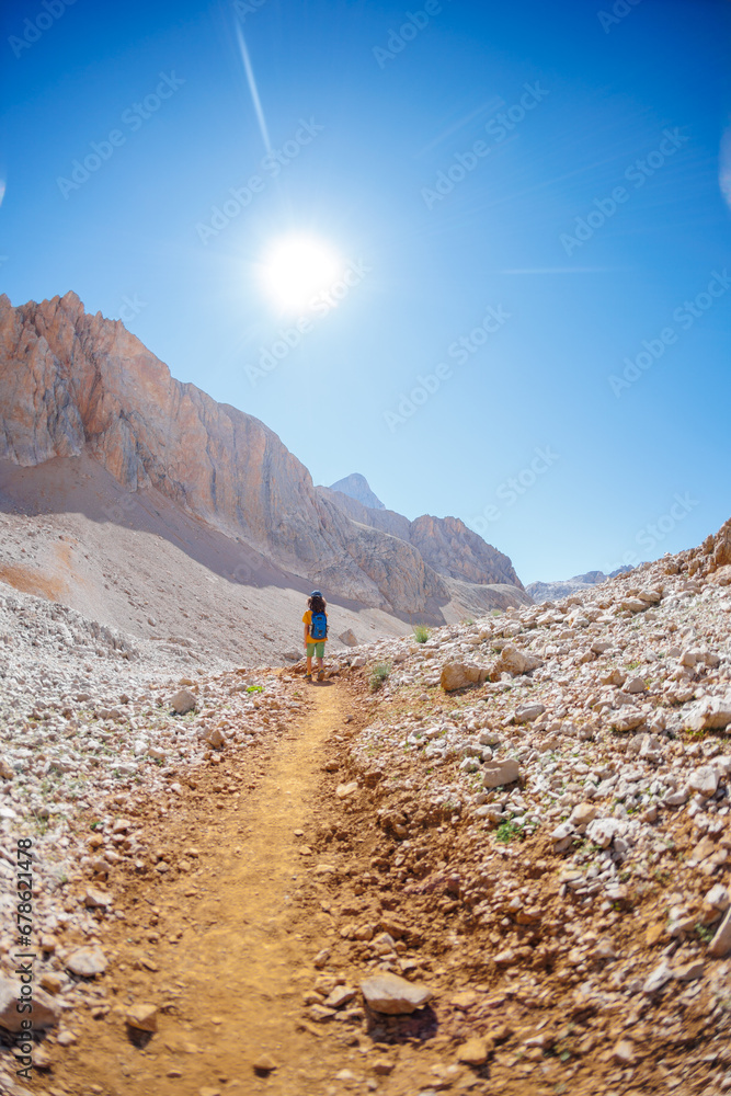 Obraz premium child travels in the mountains with a backpack. mountain hike in high mountains. Turkey.
