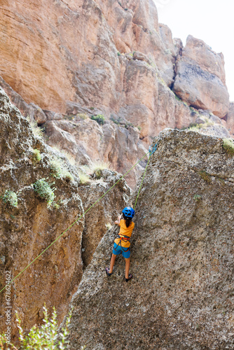 climber boy. a child in a helmet climbs a rock using equipment. children's sports.