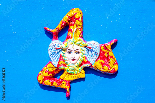 A typical ceramic trinacria, a traditional souvenir from Sicily, on a blue background. Trinakria or Trinakrien the symbol and name of the island since Homer. photo