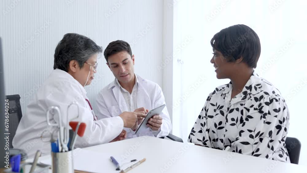 Professional elderly senior women and young man doctors giving a consulting to a mix African-American women. Healthy middle age women listening the doctor advice for annual health check up. Professional elderly senior women and young man doctors giving a consulting to a mix African-American women. Healthy middle age women listening the doctor advice for annual health check up.