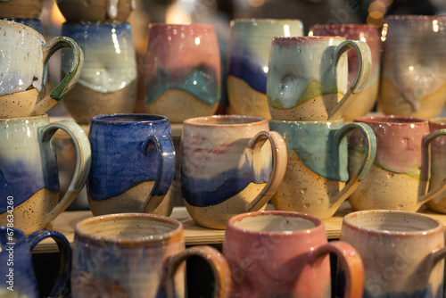 Bild auf Leinwand tea mugs made of glazed ceramics are sold at the crafts fair
