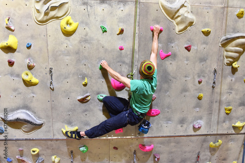 young sporty man bouldering in a climbing hall - indoor sports