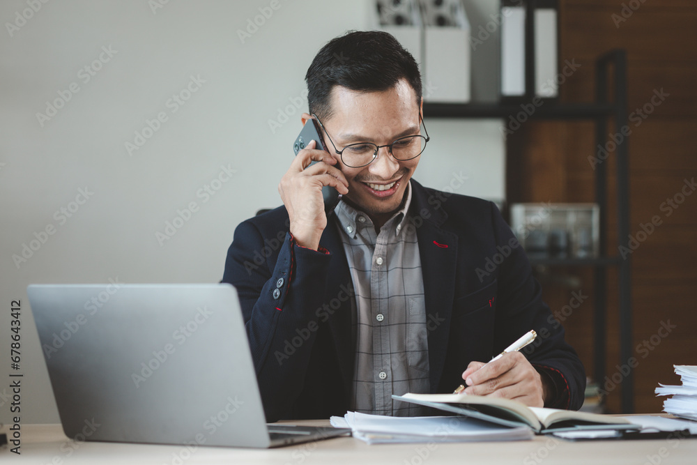 Businessman is working in the office and talking on the phone with a partner, Entrepreneurs use smartphones to find information in order to present it, Working in a private office at a company. Businessman is working in the office and talking on the phone with a partner, Entrepreneurs use smartphones to find information in order to present it, Working in a private office at a company.