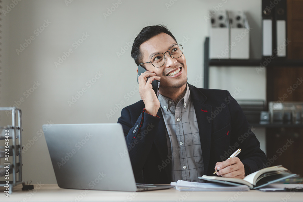 Businessman is working in the office and talking on the phone with a partner, Entrepreneurs use smartphones to find information in order to present it, Working in a private office at a company. Businessman is working in the office and talking on the phone with a partner, Entrepreneurs use smartphones to find information in order to present it, Working in a private office at a company.
